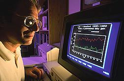 El genetista Mike MacNeil revisa los datos de apareamientos de la Linea 1 Hereford desde 1934. (K3910-14).