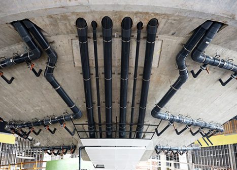 Grandes tuberías corren a lo largo de un panel de hormigón.